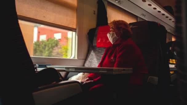 Stara kobieta nosi maskę medyczną w pociągu w okresie Covid — Wideo stockowe