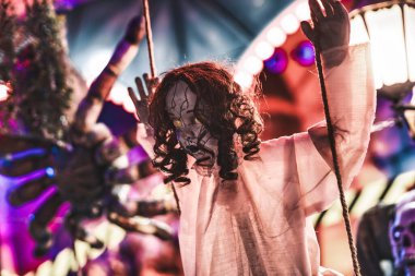 Perili bir evde salıncakta sallanan parlayan gözleri olan ürkütücü bebek Cadılar Bayramı kutlamaları ve karanlık sonbahar geceleri için mükemmel ürkütücü ve ürkütücü bir atmosfer yaratıyor.