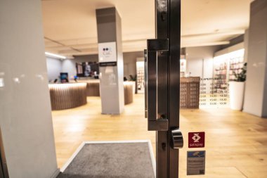 Rovigo, İtalya, 10 Eylül 2025: modern bir mağazanın cam kapısı açılış saatleri sergileniyor, müşterileri içeri davet ediyor ve Rovigo, İtalya 'da sunulan ürün ve hizmetleri araştırıyorlar.