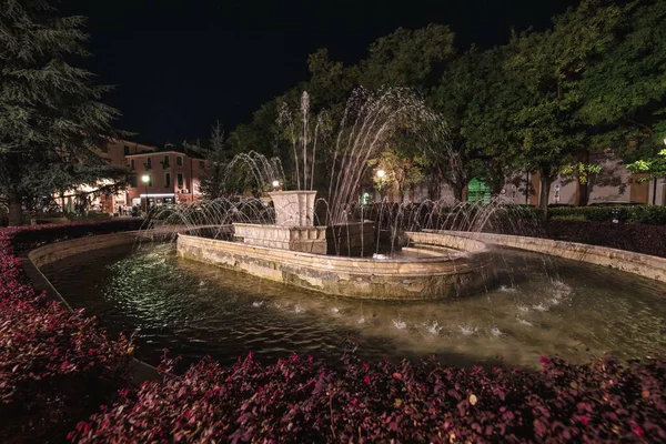Rovigo, İtalya 10 Eylül 2025 Piazza Vittorio Emanuele ii 'deki çeşmeden fışkıran su jetleri gece gökyüzünün altında büyüleyici bir manzara yaratıyor.