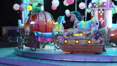 Roma, İtalya 10 Eylül 2025: Aydınlatılmış, renkli araçlarla dönen gece atlıkarıncaları ve festival ışıkları altında geleneksel atlar büyülü karnaval atmosferi yaratıyor