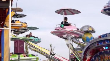 Roma, İtalya, 10 Eylül 2025: Çocuklu aileler eğlence parkında renkli uçan daireler üzerinde eğlenceli ve heyecan verici bir atmosfer yaratıyorlar.