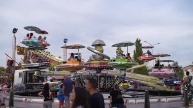 Roma, İtalya, 10 Eylül 2025: Renkli lunapark gezileri, güneşli bir günde her yaştan turistleri eğlendirmek, kahkaha ve heyecanla dolu canlı bir atmosfer yaratmak