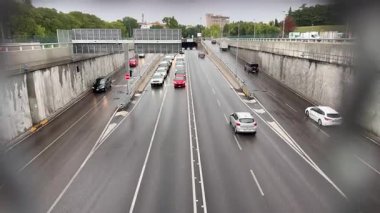 Verona, İtalya 10 Eylül 2025: arabalar çok şeritli bir yolda beton bir bariyerin yanında ilerliyor, İtalya 'nın Verona şehrinde yağmurlu bir günde tünel girişine gidiyor.