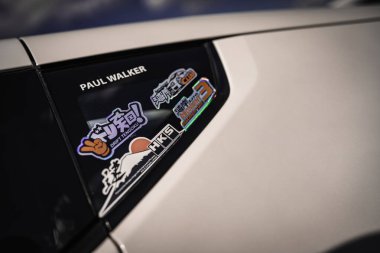 Milan, İtalya 20 Eylül 2025: Paul Walker JDM drift ve yarış çıkartmaları arasında araba camına yapıştırma yapıştırması, otomotiv tutkusu ve kişiselleştirme