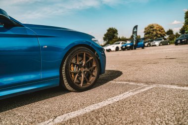 Milan, İtalya 20 Eylül 2025: bmw m serisi spor araba açık hava otomotiv etkinliğinde özel alaşım tekerlek ve fren sistemi serisi, arka planda diğer araçlar görünür