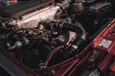 Milan, İtalya 20 Eylül 2025: antika bir arabanın motor bölmesi mekanik bileşenler, hortumlar, kablolar ve bakım ve onarım gerektiren içten yanmalı motor.