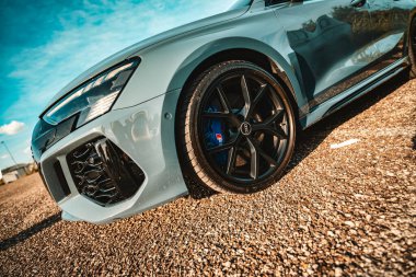 Milan, İtalya 20 Eylül 2025: 3 spor sedan Dinamik tasarım, parlak gri dış görünüş, mavi fren kalibreli performans tekerleği ve parlak gökyüzüne karşı belirgin ön ızgara