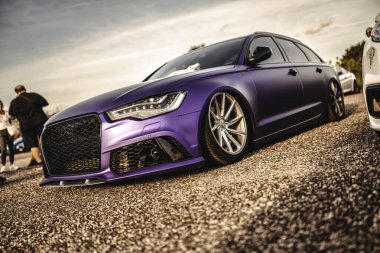 Milan, İtalya 20 Eylül 2025: Mor mat ambalajlı audi a6 özel tekerli ve çakıllı duruşu bir araba fuarında meraklıları çekiyor.