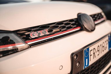 Milan, İtalya 20 Eylül 2025: Volkswagen golf gti rozeti beyaz arabanın ön ızgarasında gururla sergileniyor, performansı ve otomotiv markasını yakın çekimde vurguluyor.