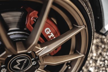 Milan, İtalya 20 Eylül 2025: Spor araba tekerleği bronz alaşımlı jant, gti markalı kırmızı fren kalibreli, ve otomotiv performansını ve ayarlarını vurgulayan bir motec merkez kapağı