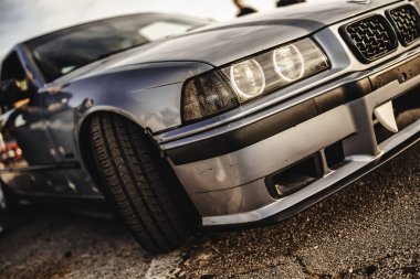 Milan, İtalya 20 Eylül 2025: bmw e36 modifiye edilmiş spor araba. Belirgin vampir dişleri ve düşük duruşu olan agresif ön tampon gösteriyor.