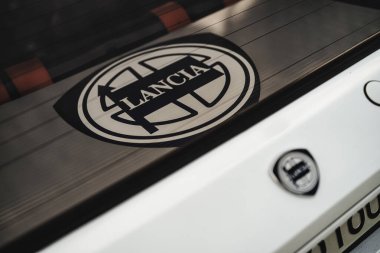 Milan, İtalya. 20 Eylül 2025. Klasik İtalyan arabasının arka camına yapıştırılmış Lancia logosu. Otomotiv markası ve klasik araç detaylarını gösteriyor.