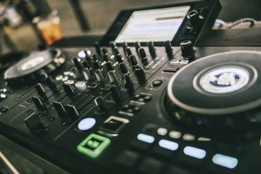 Milan, İtalya 20 Eylül 2025: DJ kontrolörü jog tekerlekleri, faderler ve aydınlatma düğmeleri ile bir partide veya festival etkinliğinde canlı bir atmosfer yaratıyor
