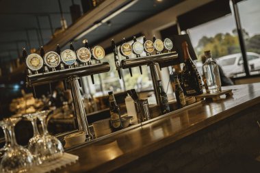 Milano, İtalya, 20 Eylül 2025: Barda çeşitli bira fıçıları, çeşitli şişe biralar ve içecekler ve gece hayatı için hoş bir ortam yaratıldı.