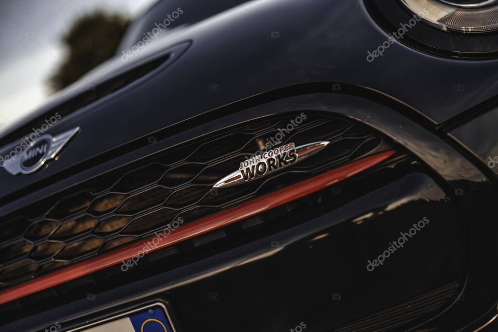 Milan, italy 20 september 2025: mini cooper john cooper works grille close-up with honeycomb pattern, emblem and bold red stripe signaling sporty performance