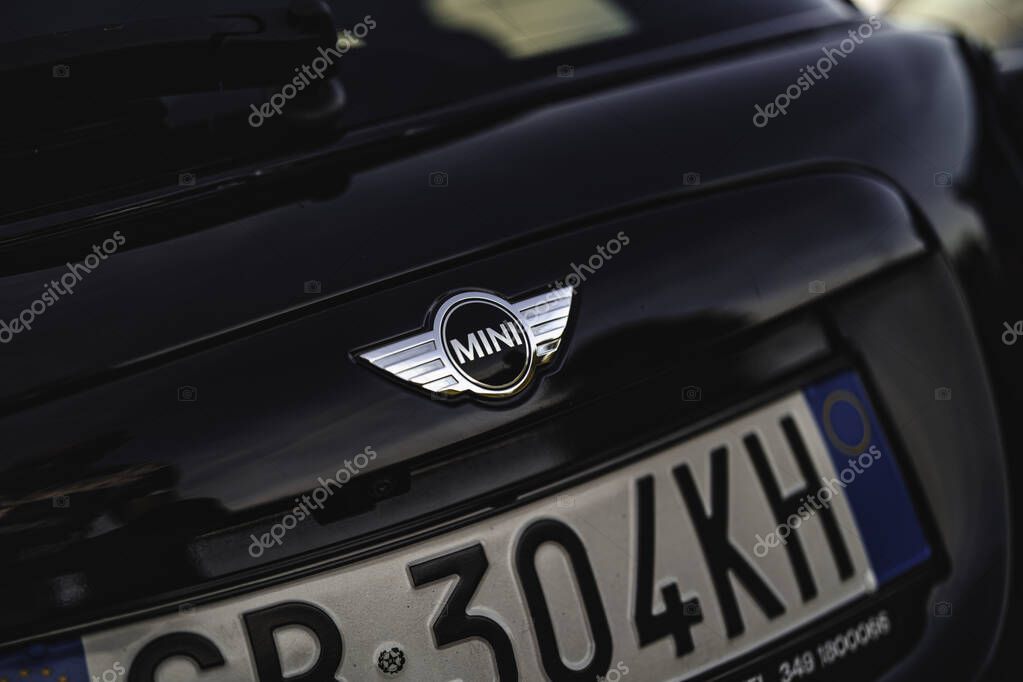Milan, italy 20 september 2025: mini cooper chrome logo on black tailgate with italian license plate, close-up detail of modern compact hatchback design