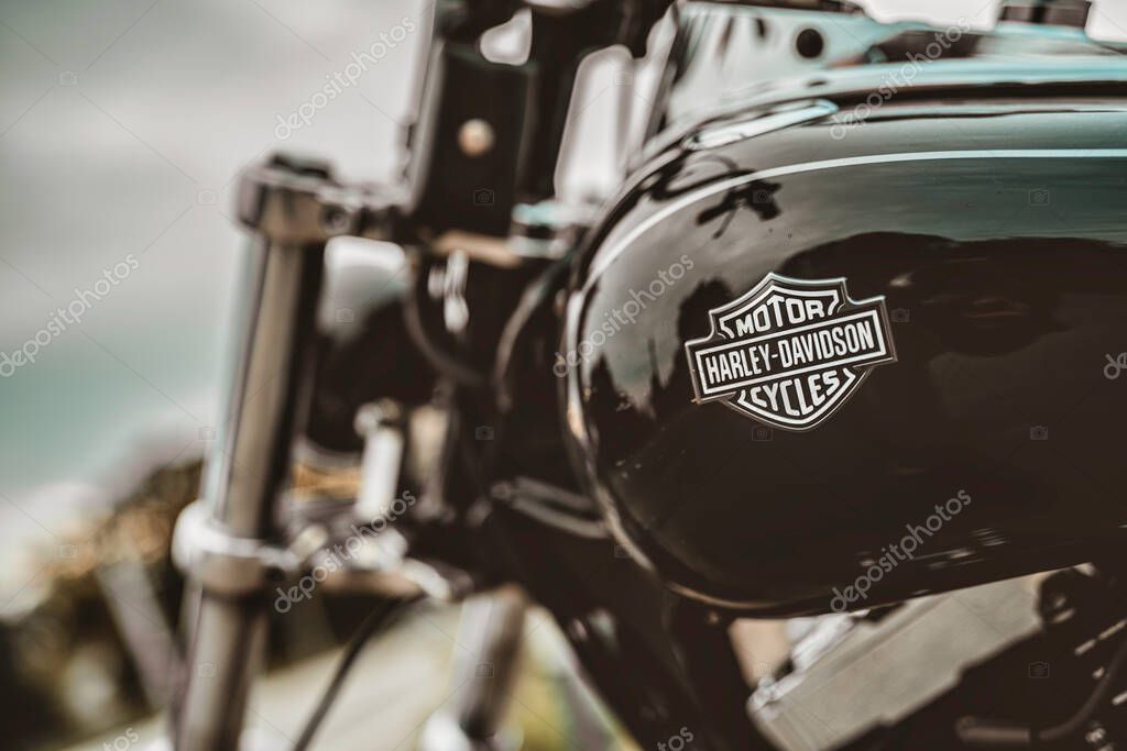 Milan, italy 20 september 2025: harley-davidson motorcycle fuel tank features its iconic badge, reflecting the spirit of freedom, adventure, and classic american engineering on a cloudy day