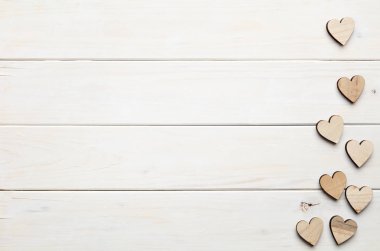 Beyaz ahşap arka plan üzerinde kalp figürleri 