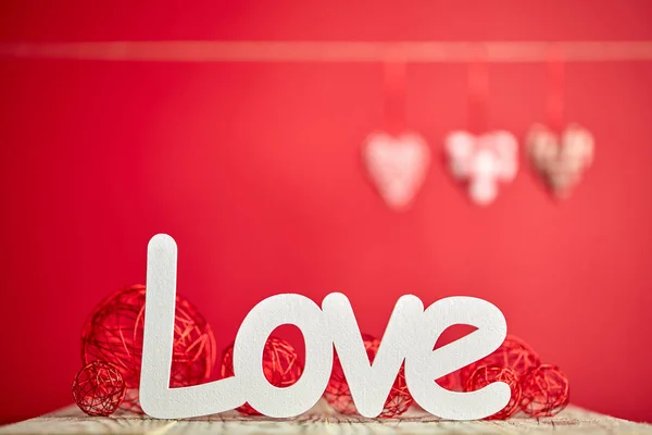 木桌上的爱标志和红色背景 带装饰品 — 图库照片