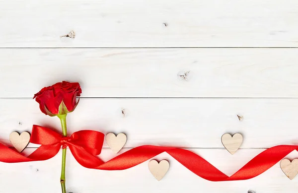白色木制背景上的单朵红玫瑰 带丝带和心 — 图库照片