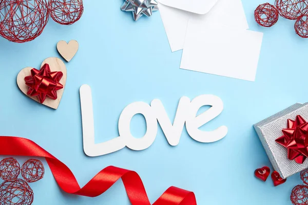 Blue plain background with silver gift, red ribbon, white letter and love sign