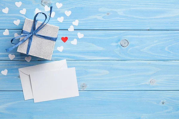 Composition of gift and white love letter on blue wooden background