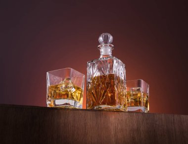 Alkol ile eski moda cam ve carafe, sıcak viski içecek, koyu turuncu arka plan ve ahşap