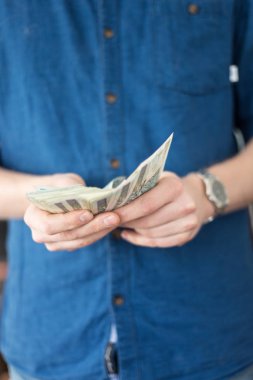 Rahat bir mavi gömlek bir adam gösterir veya Polonya para bir sürü sayar