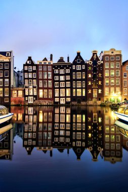 Amsterdam, Hollanda - 05 Ocak 2013: Kanal yan evleri ve Tur tekneleri ile Hollandalı sahne. Denizden şehri görmek için en iyi yollardan biridir.