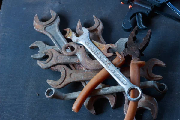 Eskimiş dokularını ve endüstriyel cazibelerini gözler önüne seren eskimiş, paslı anahtarlar ve karanlık bir yüzeyde bir kanca. Klasik alet meraklıları için mükemmel.