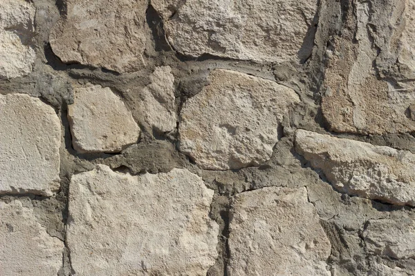 Düz olmayan büyük kireçtaşı bloklardan yapılmış eski bir duvarın dokusu