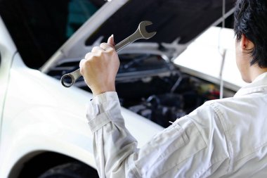 Arkadan Görünüm profesyonel mekanik anahtar araba garajda Kaputunun altında motoru tamir ile üniformalı. Araba sigortası kavramı.
