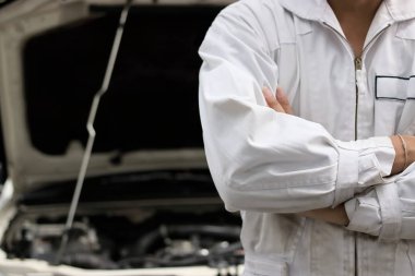 Kendine güvenen profesyonel mekanik onarım garaj kukuleta ile kişinin silah geçiş üniformalı. Araba sigortası kavramı.