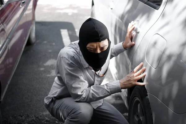 覆面をした強盗の車を背景に目出し帽の準備を着て強盗 保険犯罪概念 — ストック写真