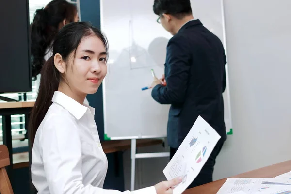 Leadership business woman concept. Confident young Asian businesswoman smiling between listening to presentation in modern office background.