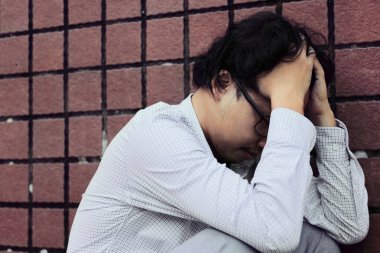 Sinirli stresli Asya iş adamı ile depresyon alnına eller yakın çekim