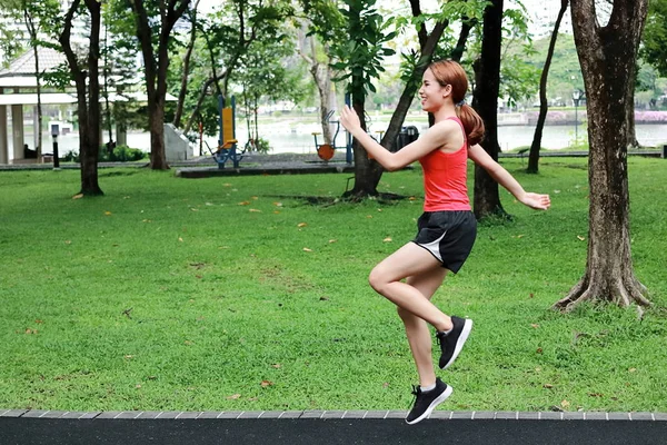 Isınma ve germe önce Park çalışma egzersiz sağlıklı Asyalı kadın. Fitness ve yaşam tarzı kavramı.