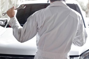 Arkadan Görünüş üniformalı otomotiv mekanik onarım garaj motoru teşhis anahtar ile. Sigorta araba konsepti.