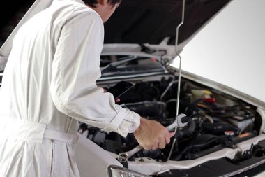 Motoru tamir garaja başlık altında teşhis anahtar ile beyaz üniformanın otomotiv mekanik görünümü arka. Araba sigortası kavramı.