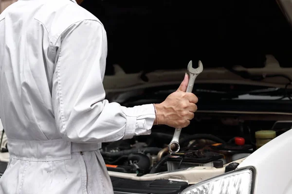 Jeune Mécanicien Professionnel Uniforme Avec Clé Diagnostiquant Moteur Contre Hotte — Photo