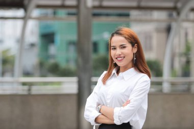 Kendine güvenen genç Asya iş kadını kişinin silah açık havada, geçiş.