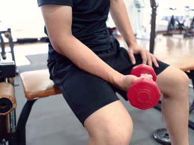 Spor salonunda halterini kaldıran zinde bir Asyalı. Fitness ve egzersiz konsepti