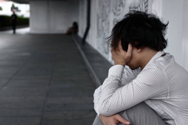 Depresyon katta oturan işsiz Asya adam üzgün