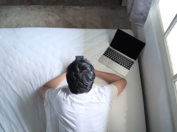 Ovanifrån Ung Man Använder Telefonen Och Laptop Sängen Sovrummet — Stockfoto