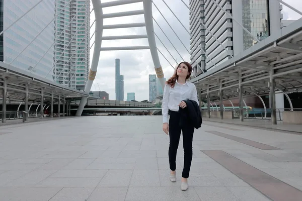 歩くと都市背景の歩道を遠くに見て魅力的な若いアジア ビジネス女性の肖像 — ストック写真