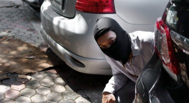 Arabaya girmeye çalışan siyah yün maskeli hırsız