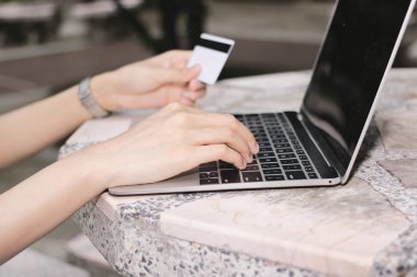 Seçici odak laptop ve online alışveriş için kredi kartı ile kadının ellerinde.