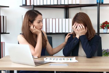 Genç Asyalı kadın ofiste depresif iş arkadaşları teselli.