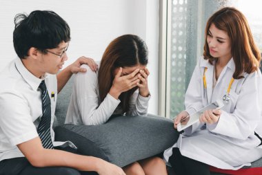 Genç bir Asyalı kadın doktor hastane ofisinde hastaya danışmanlık yapıyor. Sağlık ve tıbbi konsept.